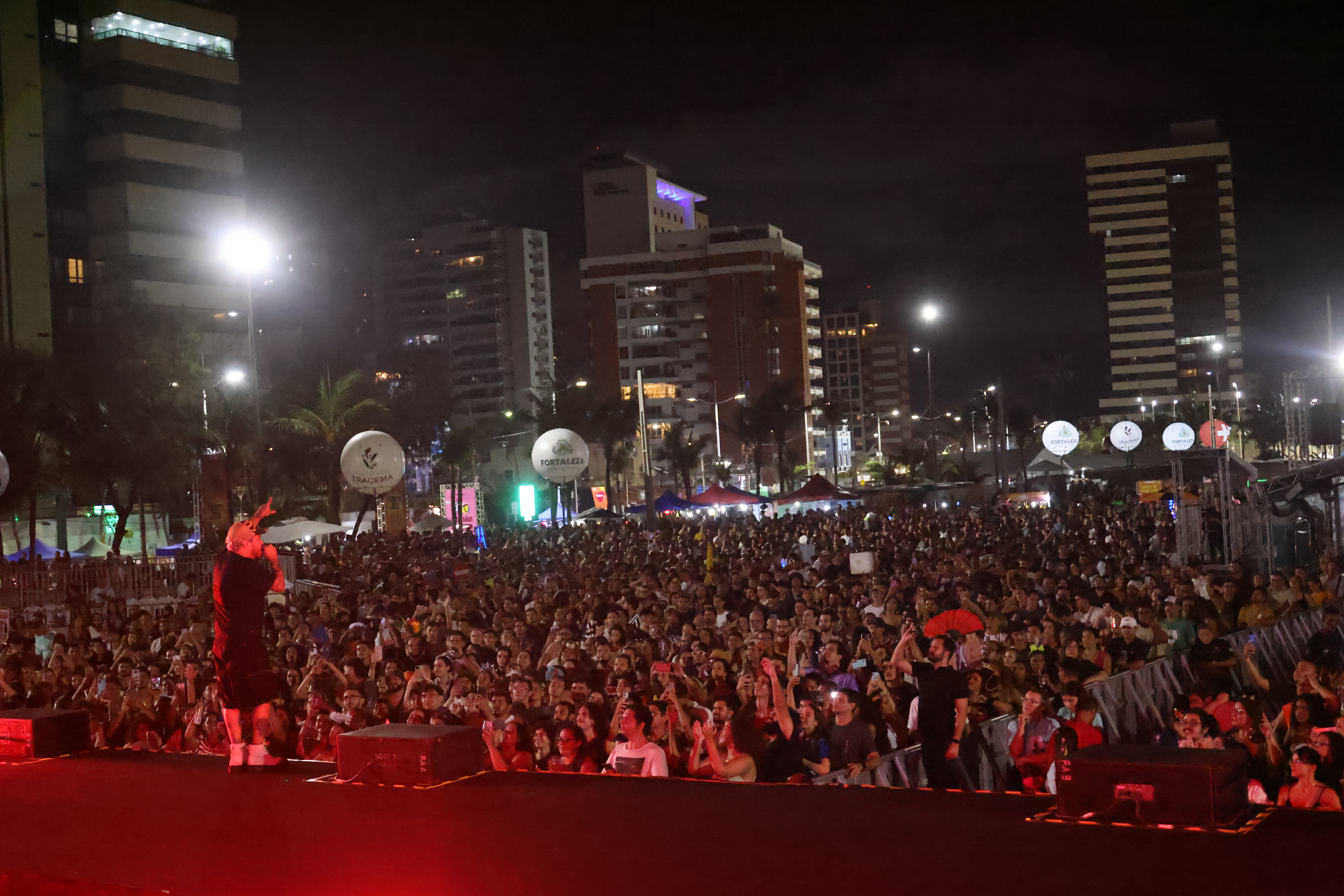 a foto mostra o show de Marcelo D2 na Praia de Iracema, destacando o público na frente do palco